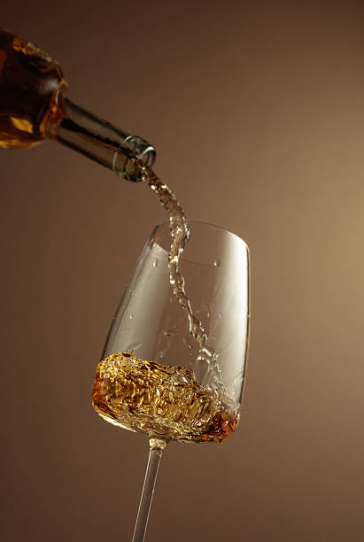 istock Pouring white wine from a bottle into a glass. 2228684356