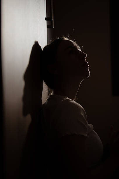 istock A woman with mental problems sits in the dark. 2228685525
