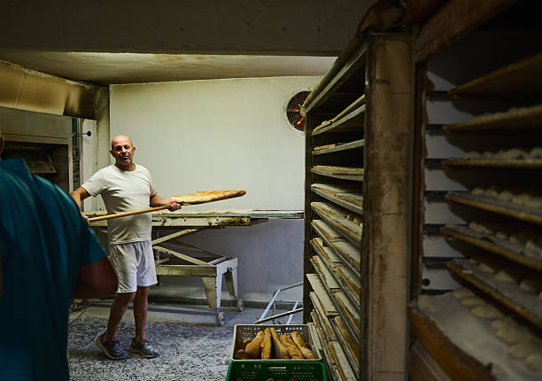 istock Artisan Baker Preparing Freshly Baked Baguettes in Traditional Bakery Setting 2228687041