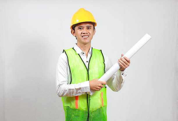 istock construction worker chief holding blueprint smiling happily isolated on white background. 2228687120