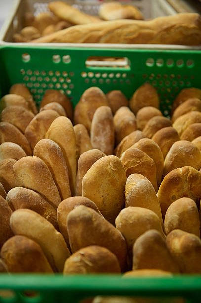 Freshly Baked Artisan Bread Loaves in Green Crates Inside a Bakery