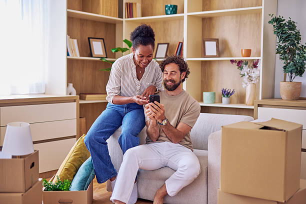 istock Couple using smartphone and taking a break while moving into new home 2228688436