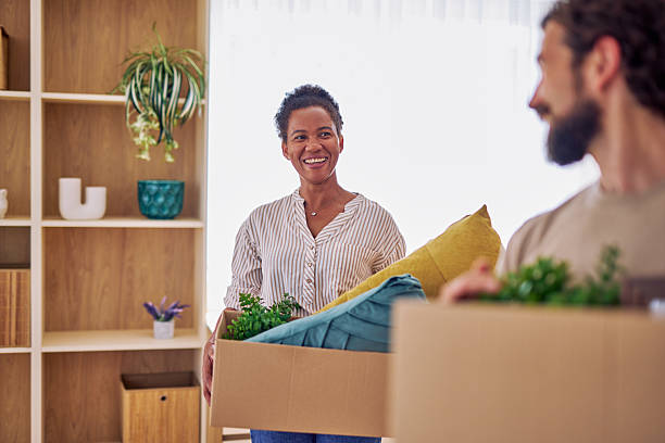 istock Happy couple carrying boxes while moving in new home 2228688441