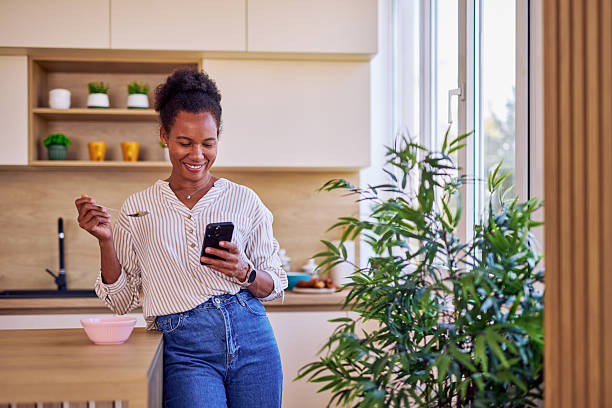 istock Woman enjoying breakfast and checking her phone in modern kitchen 2228688722