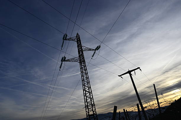 The low-angle view of a transmission tower with electric wires under the blue sky