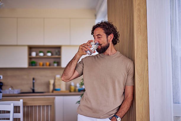 istock Man drinking fresh water in the kitchen 2228688883