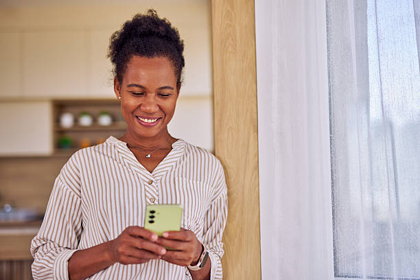 istock Smiling woman using smartphone at home 2228688961