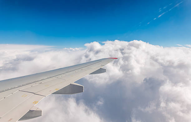 istock View from the airplane window at a beautiful cloudy sky and the airplane wing 2228690819