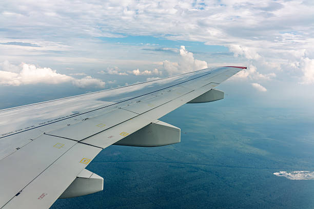 istock View from the airplane window at a beautiful cloudy sky and the airplane wing 2228690875