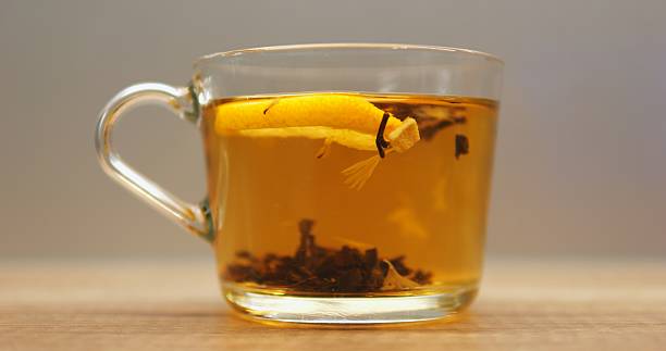 istock Transparent mug filled with herbal tea and fresh lemon slice on wooden table 2228691795