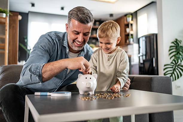 istock Father teaching son about saving money using piggy bank 2228692037