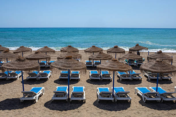 Benalmadena, Spain - April 23rd 2024: View of sunbeds on Playa de Bil-Bil, or Bil-Bil beach in the beautiful town of Benalmadena in Spain.
