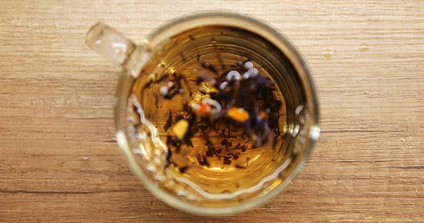 istock Colorful tea leaves rotate in transparent mug at table during brewing process 2228692757