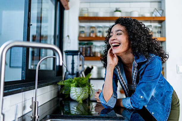 istock Young woman looking through window on kitchen at home 2228692814