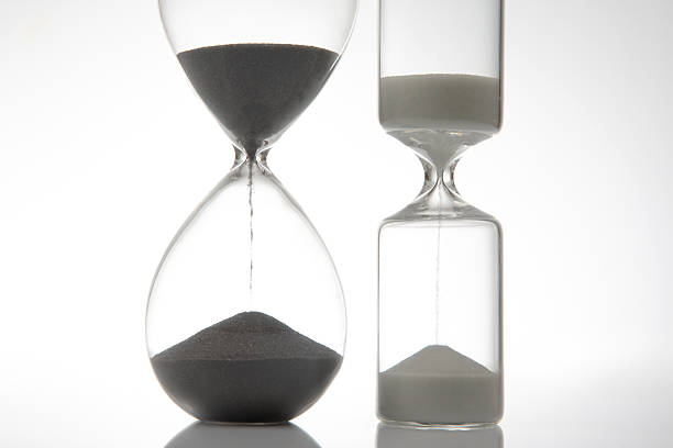 istock A sleek hourglass with dark sand flowing against a stark white background, symbolizing time. Ideal for minimalist, time-related themes 2228693658
