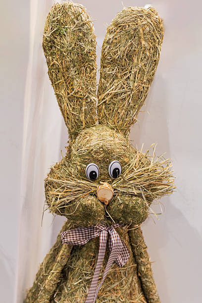 Decorative straw bunny features large ears and a cheerful face, perfect for festive occasions and seasonal decor.