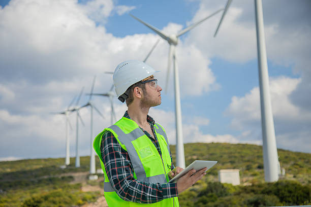 istock Engineer Man Using Digital Tablet for Wind Turbine Inspection at a Wind Farm for Renewable Energy Projects 2228703154