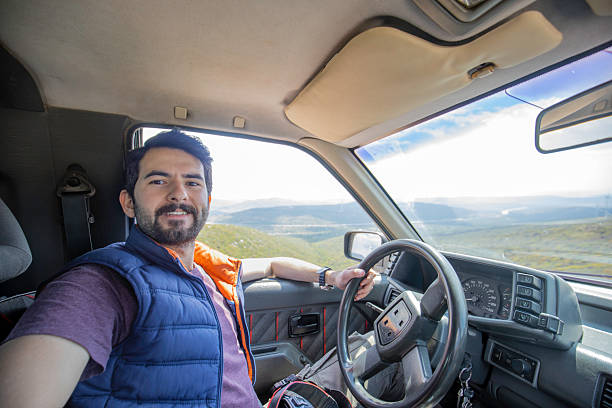 tourist rest - a man sits in the trunk of his car on the side of the road in the mountains, a beautiful landscape