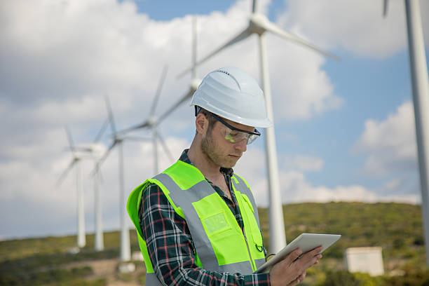 istock Engineer Man Using Digital Tablet for Wind Turbine Inspection at a Wind Farm for Renewable Energy Projects 2228703157