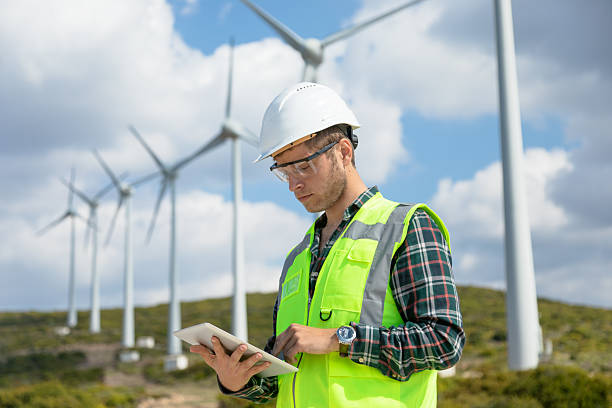 istock Engineer Man Using Digital Tablet for Wind Turbine Inspection at a Wind Farm for Renewable Energy Projects 2228703174