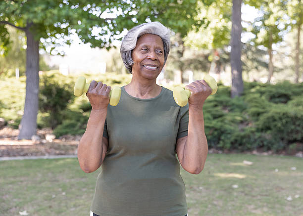 istock Senior woman using hand weights in a park 2228709464