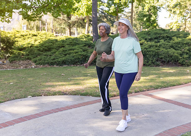 istock Two senior women walking in a public park 2228709558