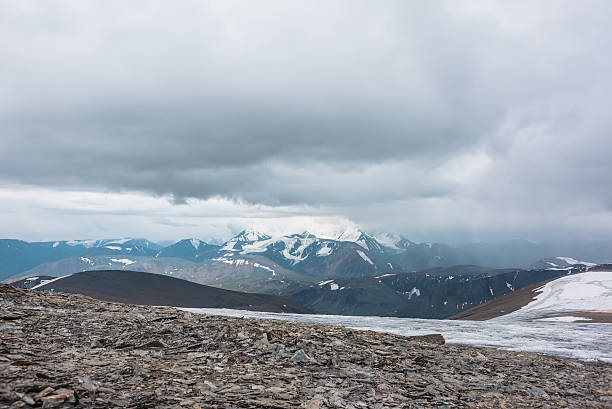 istock Dramatic panoramic view from big glacier to wide alpine valley and large snow-capped mountain range in rainy low clouds. Awesome vast landscape with high snowy mountains in rain under gray cloudy sky. 2228714893