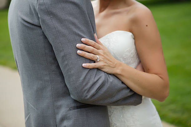 istock Bride embraces groom’s arm, highlighting wedding ring and love 2228715521