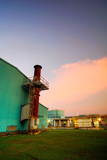 Industrial dawn: A power station stands against a dynamic sky transitioning from fiery orange to deep twilight blues creating an evocative
