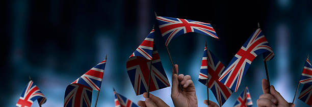 istock United Kingdom flags in their hands on a blurred urban background 2228721576