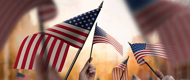 istock USA flags in their hands on a blurred urban background 2228721607