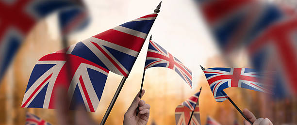 istock United Kingdom flags in their hands on a blurred urban background 2228721613