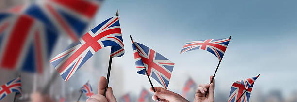 istock United Kingdom flags in their hands on a blurred urban background 2228721659
