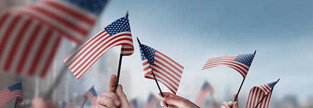 istock USA flags in their hands on a blurred urban background 2228721672