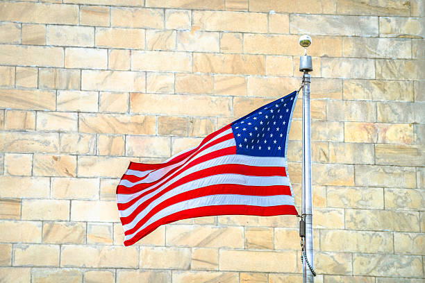 istock USA flag on Washington monument background view, Washington DC 2228722750