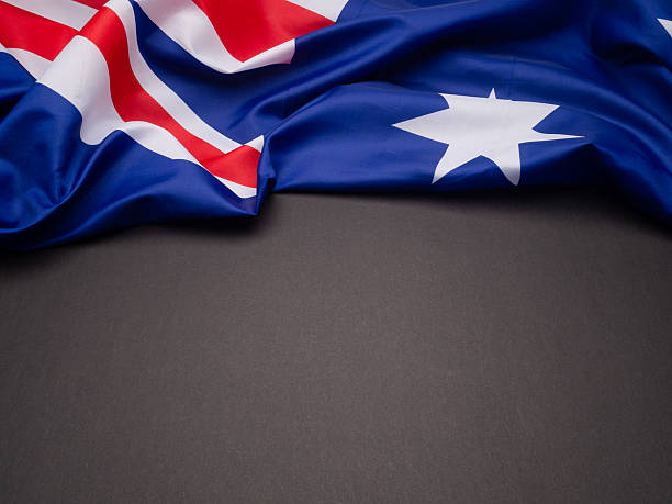 istock Australian national flag draped over dark surface with copy space, symbolizing patriotism. 2228724069