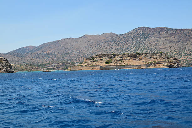 Crystal-clear turquoise waters  on Favignana Island, Sicily, with submerged rocks and weathered limestone formations along the rugged shoreline