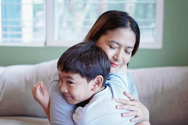 istock Son embraces his mother warmly on the sofa. 2228736609