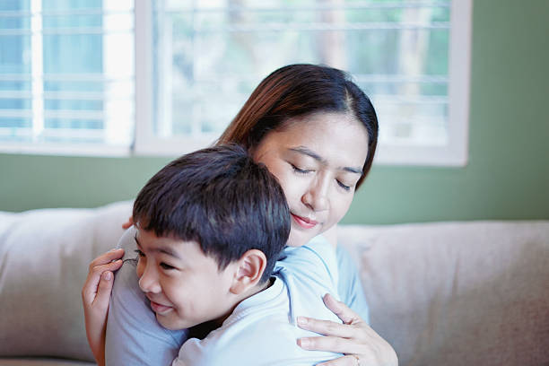 istock Son embraces his mother warmly on the sofa. 2228736615