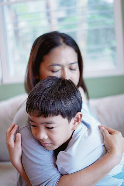 istock Son embraces his mother warmly on the sofa. 2228736616