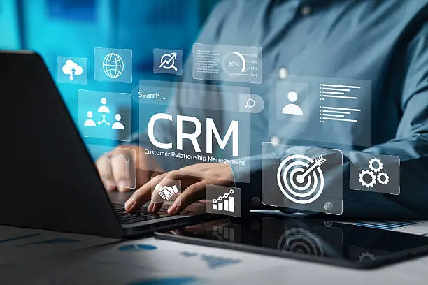 Photo of Businessman using computer and dashboard to analyze CRM data on virtual technology screen with CRM icon, customer relationship management concept for connecting business technology database.