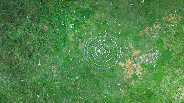 Mystical stone formation forming circular pattern in green field, captured by drone from above