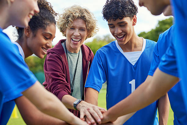 istock Sports team stacking hands before playing football match 2228740018