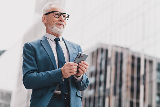 istock Confident businessman in formal suit using smartphone in urban outdoors, professional broker or manager planning work 2228743610