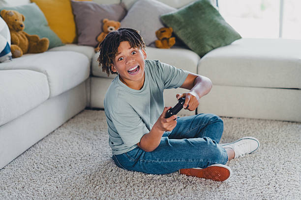 istock Joyful boy enjoying a gaming session in a cozy living room with a controller 2228743670