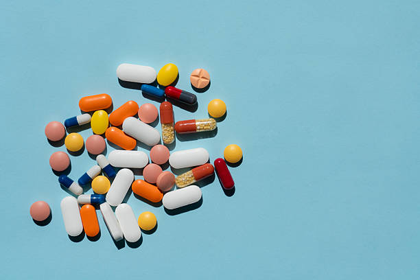 istock Large group of assorted capsules and pills on blue background 2228744549