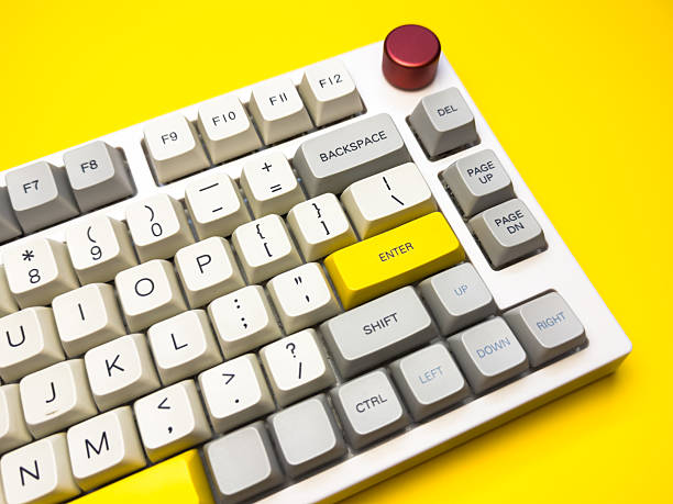 istock White mechanical keyboard with bright Enter key on bright yellow background, minimalism, keyboard buttons. A keyboard with a yellow key on the bottom left 2228744609