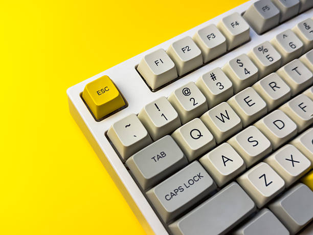 istock White mechanical keyboard with bright Esc key on bright yellow background, minimalism, keyboard buttons. A keyboard with a yellow key on the bottom left 2228744726