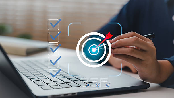 istock Business hand pointing to digital target icon on laptop, symbolizing goal setting, task management, focus, and productivity. Concept for performance tracking and strategic planning tools. 2228746125
