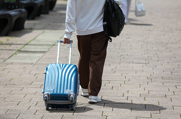istock A man is walking down the street with a blue suitcase 2228747928